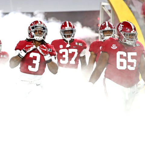 Alabama players run onto the field before the titl