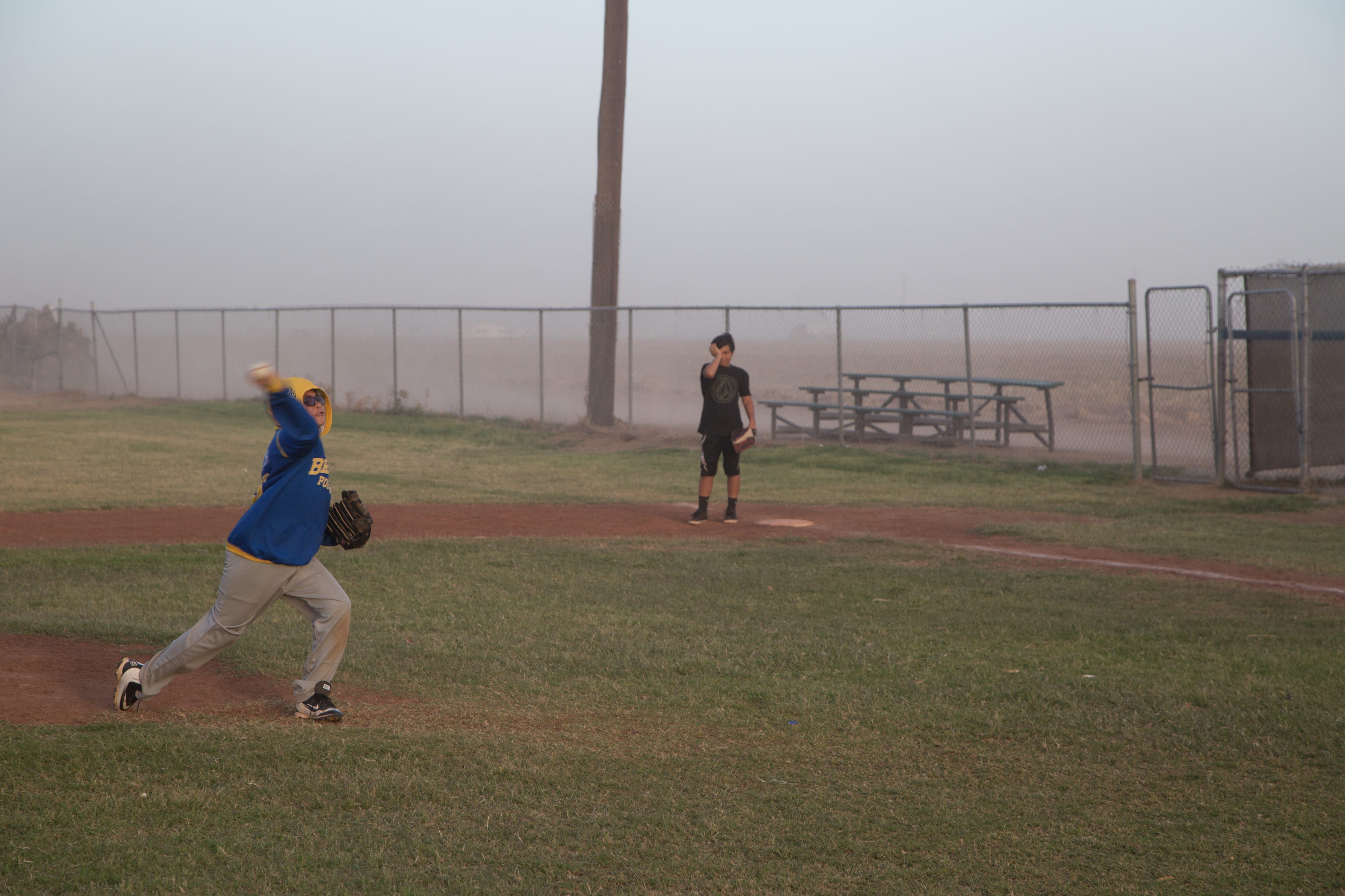 Los niños juegan béisbol durante una tormenta de polvo en West Moreland, California, el 30 de marzo de 2017.