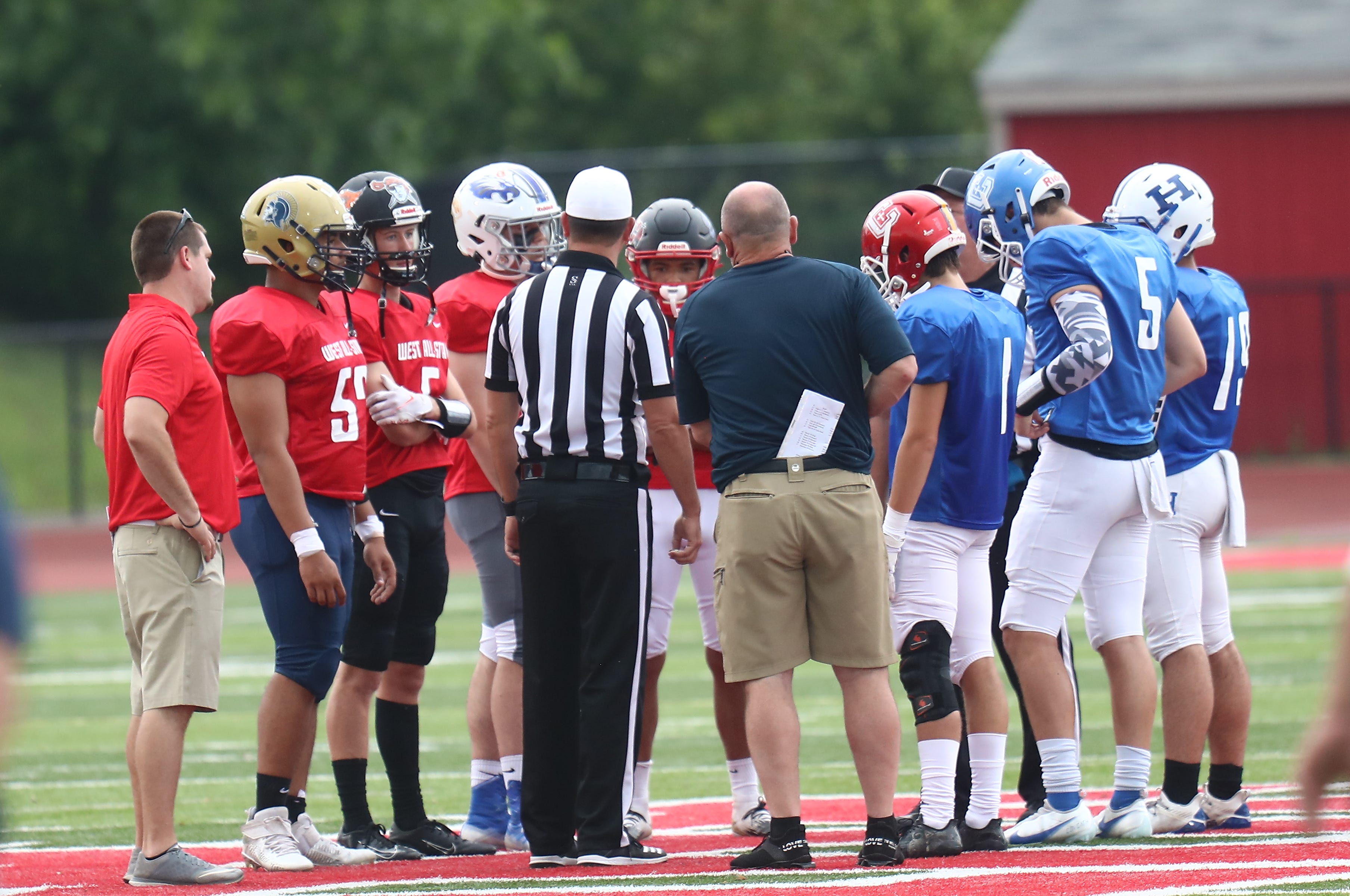 Captains from the East and West teams meet before their all-star football game, Thursday, June 10, 2021.