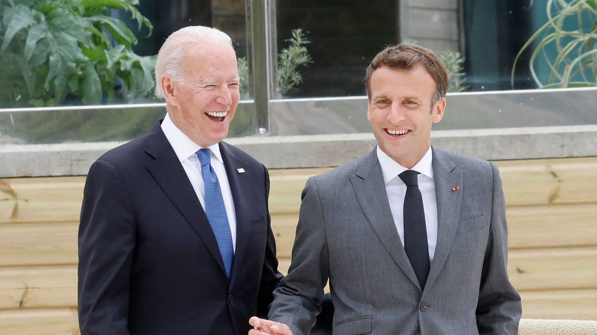 US President Joe Biden and France's President Emmanuel Macron share a light moment before the family photo at the start of the G7 summit in Carbis Bay, Cornwall on June 11, 2021.