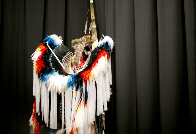 Jay Mule, who is Kiowa and Choctaw, watches his daughter dance Saturday during the Red Earth Festival.
