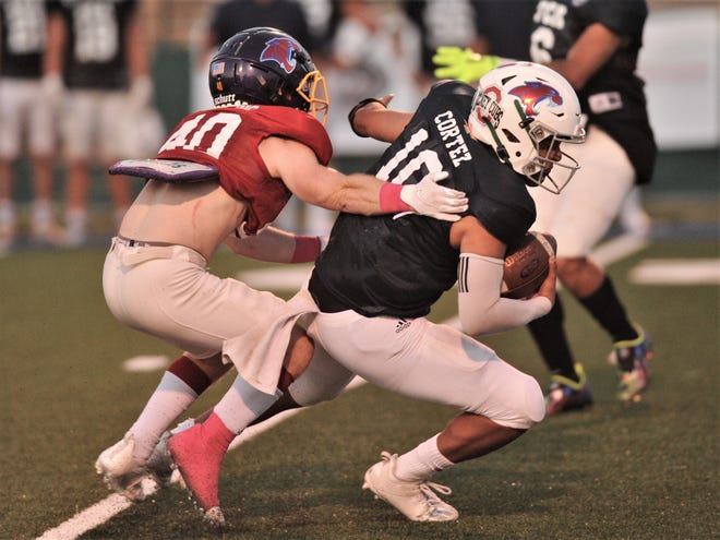 Wylie's Reese Gooding, left, sacks Bangs' quarterback Ethan Cortez during the 2021 Big Country FCA Myrle Greathouse All-Star Classic football game on June 12.
