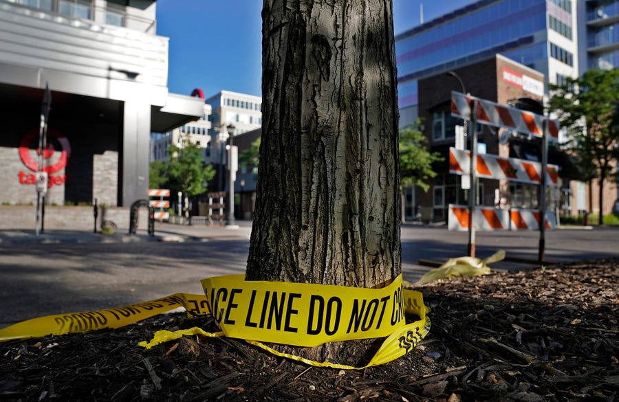 Discarded police tape lays outside a Target Monday, June 14, 2021, in Uptown Minneapolis.  Minneapolis police and witnesses say a woman was killed and multiple others were injured when an SUV struck a parked car and tossed it into demonstrators during a protest late Sunday in Minneapolis.