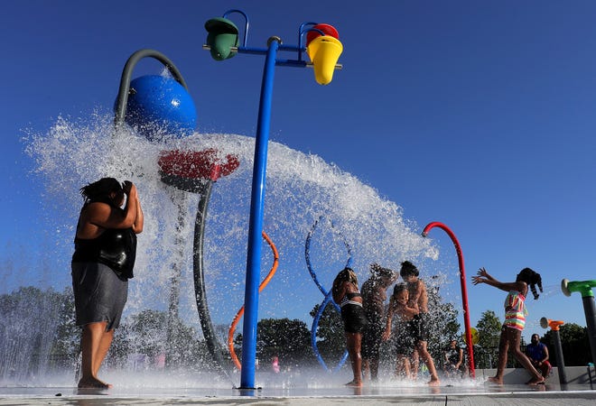 Children are doused with water at the Linden Community Center splash pad on Monday, June 14, 2021.