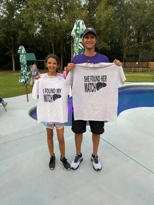 Cecilia Shaffette and her father, Rhett, hold up matching T-shirts before their surgeries during a transplant party they threw in their backyard Carriere, Miss.