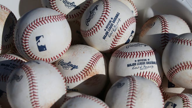 FILE - In this Feb. 14, 2020, file photo, baseballs sit in a bucket after they were used for fielding practice during spring training baseball workouts for pitchers and catchers at Cleveland Indians camp in Avondale, Ariz. Pitchers will be ejected and suspended for 10 games for using illegal foreign substances to doctor baseballs in a crackdown by Major League Baseball that will start June 21. The commissionerâ€™s office, responding to record strikeouts and a league batting average at a more than half-century low, said Tuesday, June 15, 2021 that major and minor league umpires will start regular checks of all pitchers, even if opposing managers donâ€™t request inspections. (AP Photo/Ross D. Franklin, File)