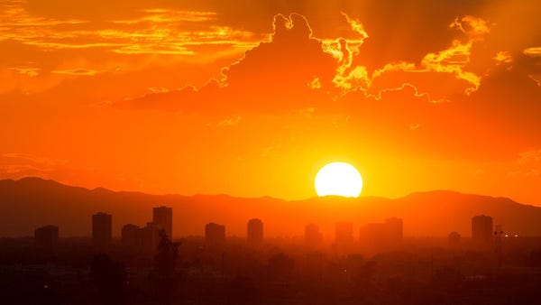 Scottsdale and Phoenix, Ariz.: The sun sets over d