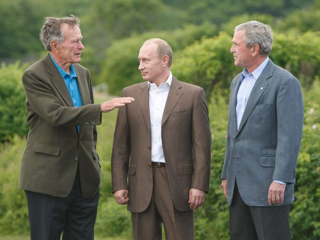 Former President George Bush, left and President George Bush, right welcome Russian President Vladimir Putin to Walker's Point, the Bush family compound in Kennebunkport, Maine, July 1, 2007.
