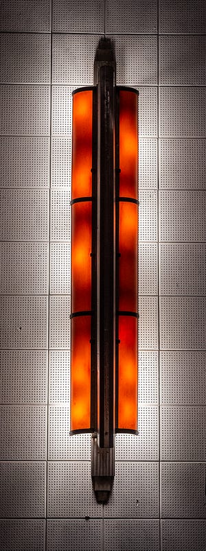 Apliques de pared originales, de 1925, ahora alimentados por bombillas, adornan las paredes dentro del Newtown Theatre.