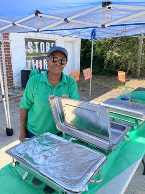 Habiba Ismail si prepara a servire il cibo sotto una tenda di fronte al Congaree Golf Club.  Stava lavorando per aiutare a promuovere College Hunks Hauling Junk and Moving.  È una residente di Gillisonville che vive a pochi passi dal corso.