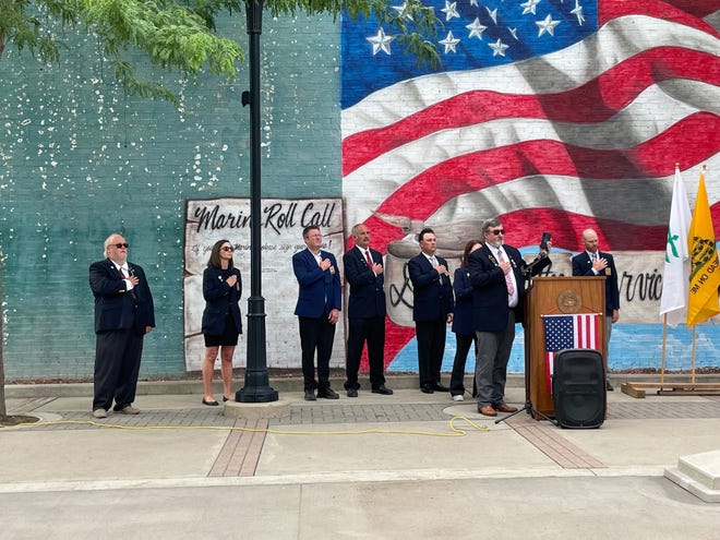 From left, Inner Guard Dave Davis, Trustee Heather Erickson, Leading Knight Travis Landgrebe, Loyal Knight Bob Muir, Lecturing Knight Joe Schieb, Exalted Ruler Amber Green, Esquire Eric Derry and Chaplain John Erickson listen to the national anthem during a Flag Day program on June 14, 2021, at Josh Davis Memorial Plaza.