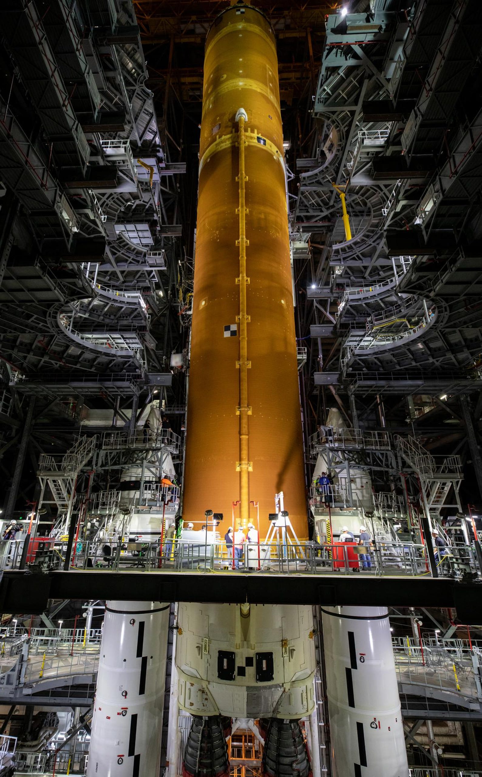 Teams with NASA’s Exploration Ground Systems and contractor Jacobs lower the Space Launch System (SLS) core stage – the largest part of the rocket – onto the mobile launcher, in between the twin solid rocket boosters, inside the Vehicle Assembly Building at NASA’s Kennedy Space Center in Florida on June 12, 2021.