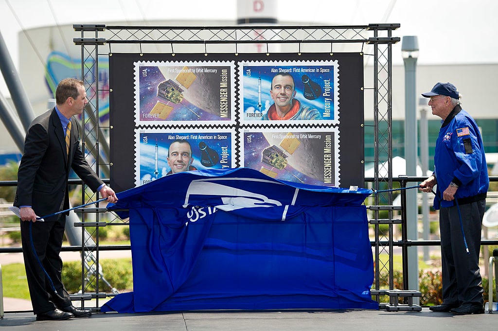 In this handout image provided by NASA, United States Postal Service Vice President of Finance Steve Masse, left, and NASA Mercury Astronaut Scott Carpenter, unveil two USPS stamps to commemorate and celebrate 50 years of US Spaceflight and the MESSENGER program during an event at the NASA Kennedy Space Center May 4, 2011 in Cape Canaveral, Florida.  One stamp commemorates NASA's Project Mercury, America's first manned spaceflight program, and NASA astronaut Alan Shepard's historic flight on May 5, 1961, aboard spacecraft Freedom 7.  The other stamp draws attention to NASA's unmanned MESSENGER mission, a scientific investigation of the planet Mercury.