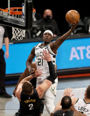 Jrue Holiday of the Milwaukee Bucks elevates for a layup over Blake Griffin of the Brooklyn Nets.