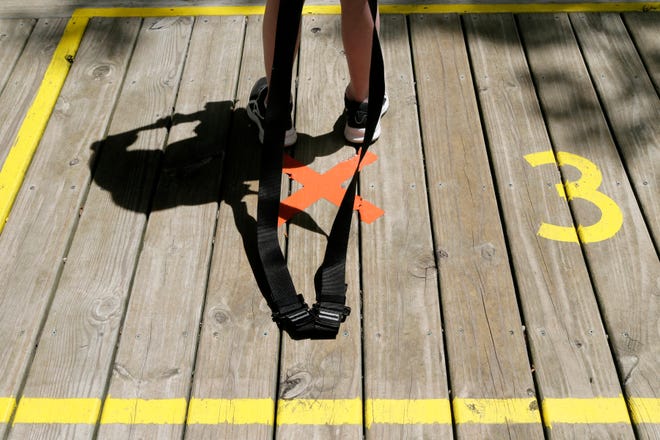 Campers put on harnesses inside painted squares promoting social distancing before a ziplining session at ZipZone inside Camp Mary Orton in north Columbus on Wednesday, June 16, 2021.