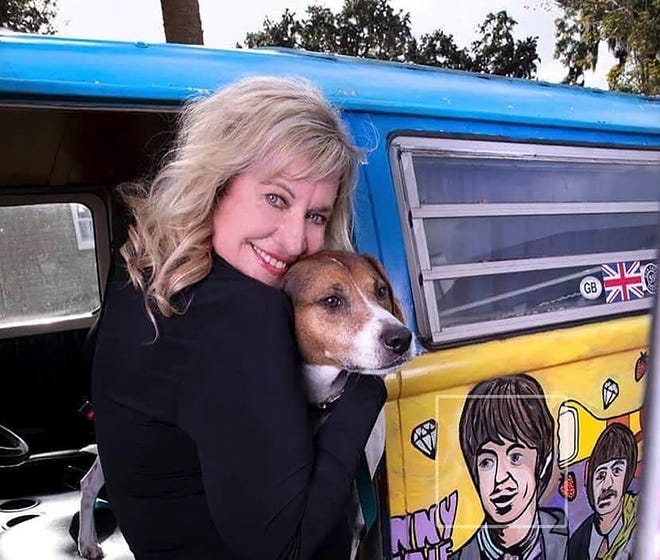Marie Rich hugs her pup in front of her famous hippie van. [Facebook]