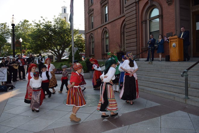 Dançarinos do Grupo Folclórico da Discovery Language Academy se apresentam em uma cerimônia de hasteamento da bandeira portuguesa em frente à Câmara Municipal de New Bedford em 2021.