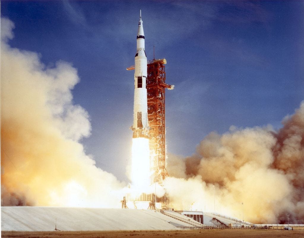 The Apollo 11 Saturn V space vehicle lifts off 16 July 1969 with astronauts Neil A. Armstrong, Michael Collins, and Edwin E. Aldrin aboard.  Druing the eight day mission, Armstrong and Aldrin descended to the the moon for 22 hours, including 2 and 1/2 hours outside the lunar module, while Collins orbited overhead in the command module.  Armstrong and Aldrin gathered samples of lunar material and deployed scientific experiments before joining Collins for the return trip to Earth.