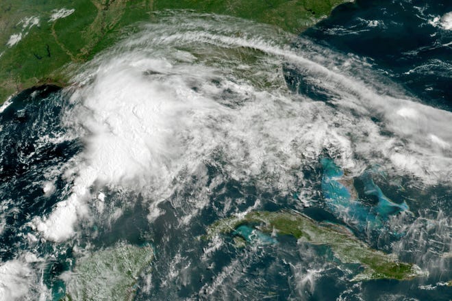 This GOES-16 GeoColor satellite image taken Friday, June 18, 2021, at 11 a.m. EDT, and provided by NOAA, shows a tropical weather system in the Gulf of Mexico. Officials ordered a floodgate and locks system closed in southeast Louisiana and readied sandbags in Mississippi and Alabama as a broad, disorganized tropical weather system began spinning bands of rain and brisk wind across the northern Gulf of Mexico coast Friday. (NOAA via AP)
