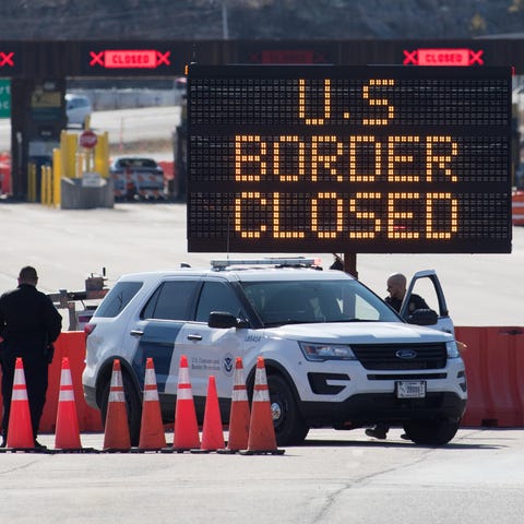 U.S. Customs officers stand beside a sign saying t