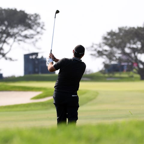 A golfer plays a shot on the 14th fairway during t