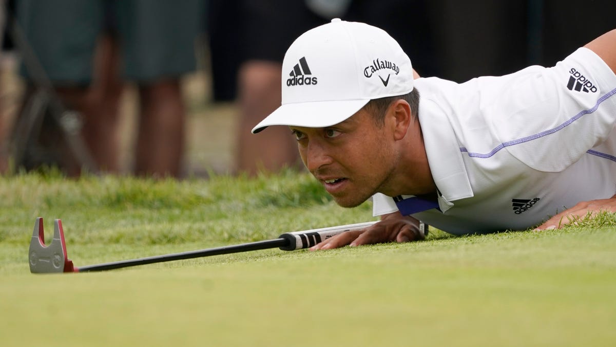 Xander Schauffele lies down to read the second green in the third round.