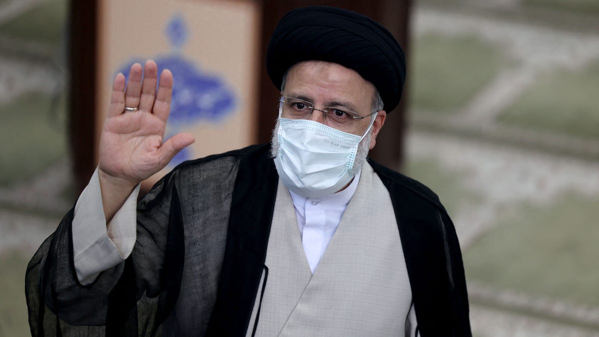 Iranian ultraconservative cleric and presidential candidate Ebrahim Raisi waves as he votes at a polling station in the capital Tehran, on June 18, 2021.