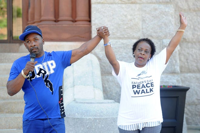 Jamal Gooding, operations manager at a Brockton group called P.A.C.C., left, which stands for People Affecting Community Change, with organizer Sharon Baker during the third annual Father's Day Peace Walk in Brockton on Sunday, June 20, 2021.