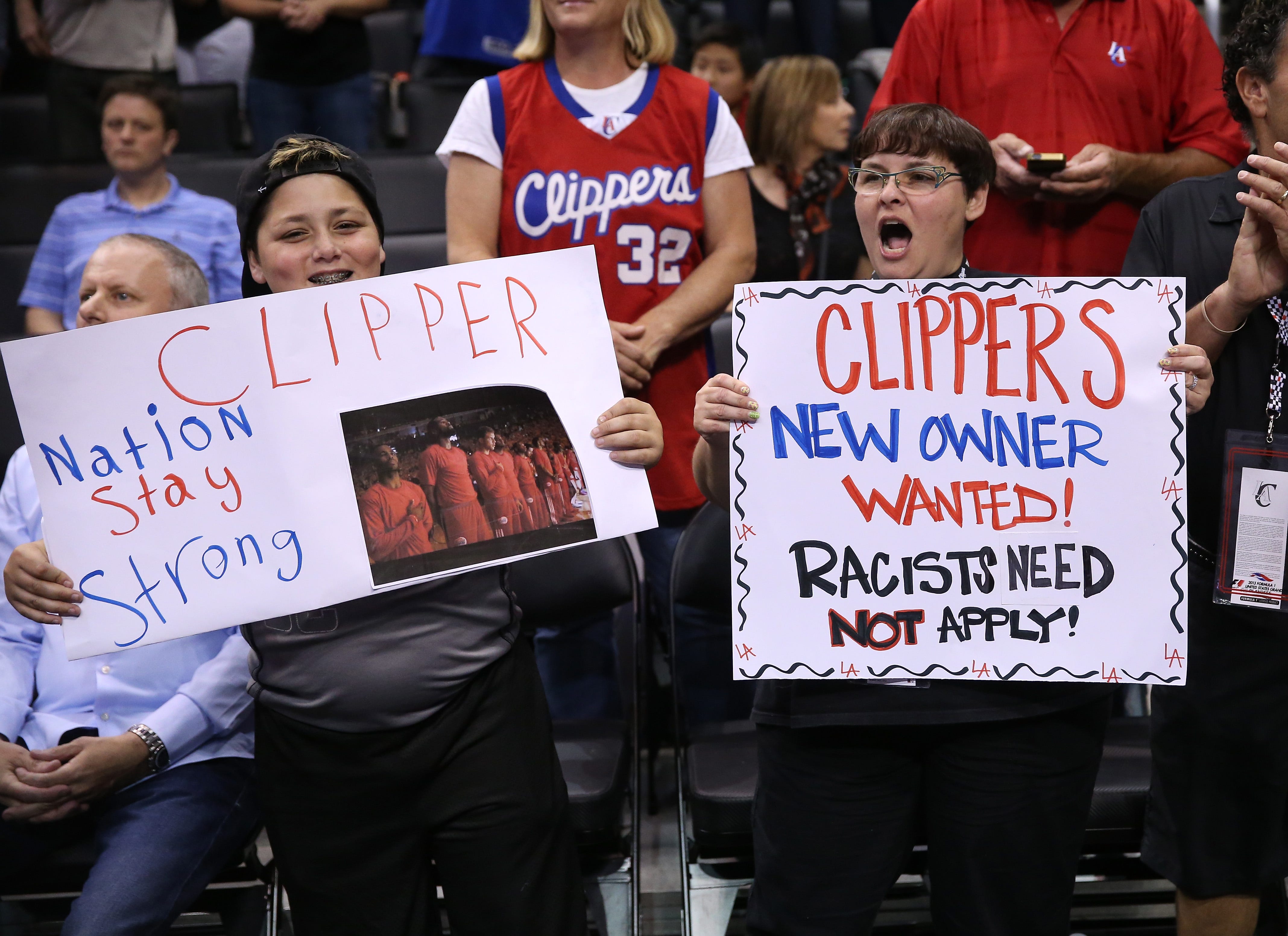 Clippers fans hold up signs referencing the Donald Sterling situation before the game with the Golden State Warriors in Game Five of the Western Conference Quarterfinals during the 2014 NBA Playoffs at Staples Center.