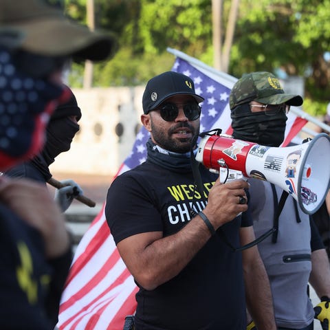 Enrique Tarrio (C), leader of the Proud Boys, uses