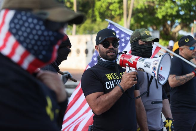 Enrique Tarrio, leader of the Proud Boys, uses a megaphone at the Torch of Friendship rally in Miami on May 25, 2021, the one-year anniversary of the murder of George Floyd.