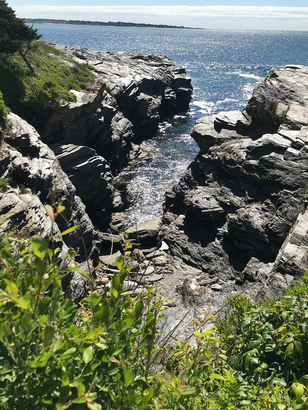 Craggy rocks border a view of the ocean.