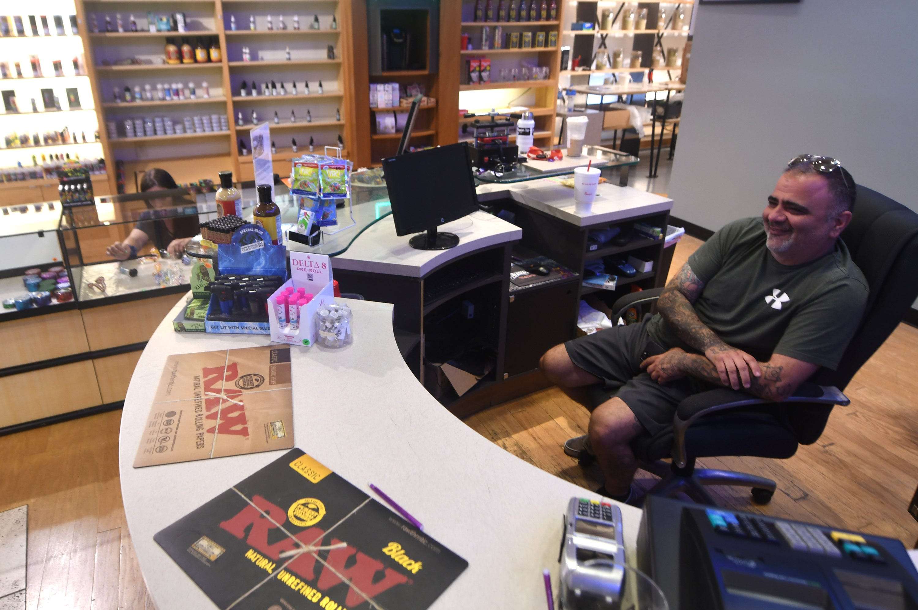 Business owner Justin LaNasa sits behind the counter at Port City Vapor Kava & Oxygen Bar at Independence Mall in Wilmington, N.C., in June 2021.