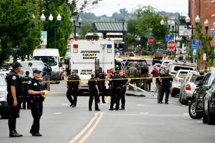 Police officers investigate the scene of a shooting  June 21 in Arvada, Colo. One of the two people killed was a police officer.