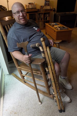 Retiring Monroe High School special education teacher Tim Toth sits beside just a few of the many wooden canes that were made for him by his students over the nearly 37 years he's taught in the district. Toth's official retirement date is Wednesday.