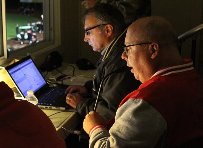 Retiring Monroe High School special education teacher Tim Toth sits in the broadcast booth at a Trojans football game, as Monroe News Sports Editor Niles Kruger sits beside him. Toth has been the announcer for Trojan football since the early 2000s, and he intends to return to the position in the fall after taking last year off due to the coronavirus pandemic.