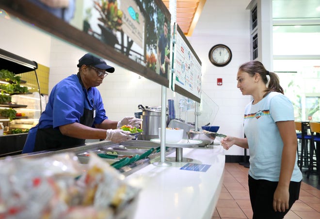 A student goes through the salad bar at the Gator Dining Services Broward Dining Hall on the University of Florida campus in Gainesville.