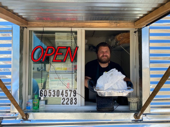 Bryant Bain serves an order at his new food truck Bain's Barbecue.