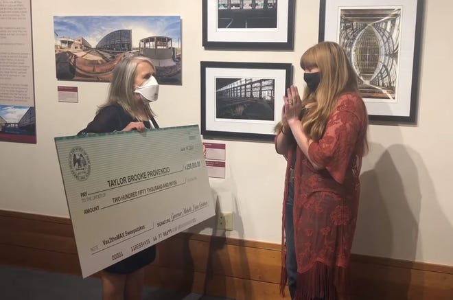 Taylor Brooke Provencio, right, receives an oversized check for $250,000 from New Mexico Gov. Michelle Lujan Grisham on Tuesday, June 23, 2021. Provencio, of Chamberino, was one of the first four winners of the state's Vax 2 the Max Sweepstakes, providing incentives for residents who receive the COVID-19 vaccine.