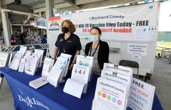 Rockland County Department of Health workers Shari Stopler, left, and Agustina Lopez-Novillo direct people to a COVID-19 vaccine pop-up clinic at Palisades Credit Union Park in Pomona June 23, 2021. The clinic was set up for people attending graduations at the stadium.