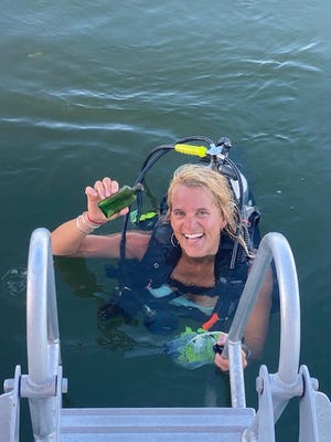 Jennifer Dowker was scuba diving when she spotted a green bottle on top of a fish bed.