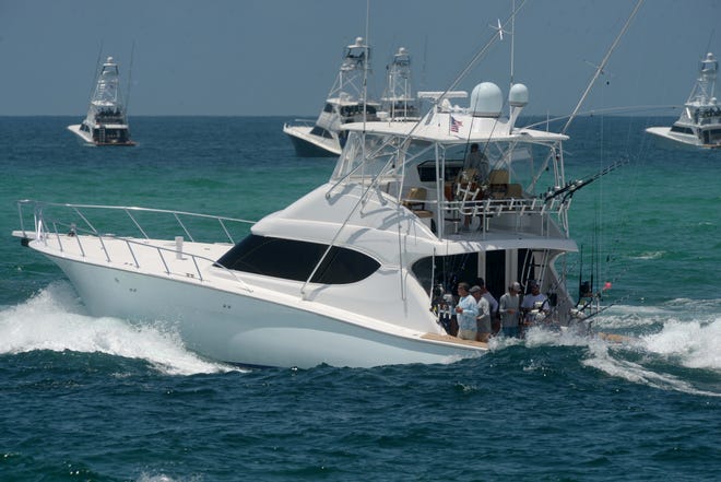 Fishing boats depart the East Pass in Destin Thursday afternoon at the start of the 19th Annual Emerald Coast Blue Marlin Classic.