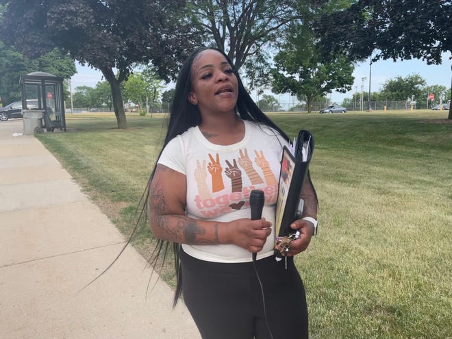 DeShawnda Bailey, who taught special education at Milwaukee Public Schools, stands outside the district's offices calling for answers after she was arrested there.