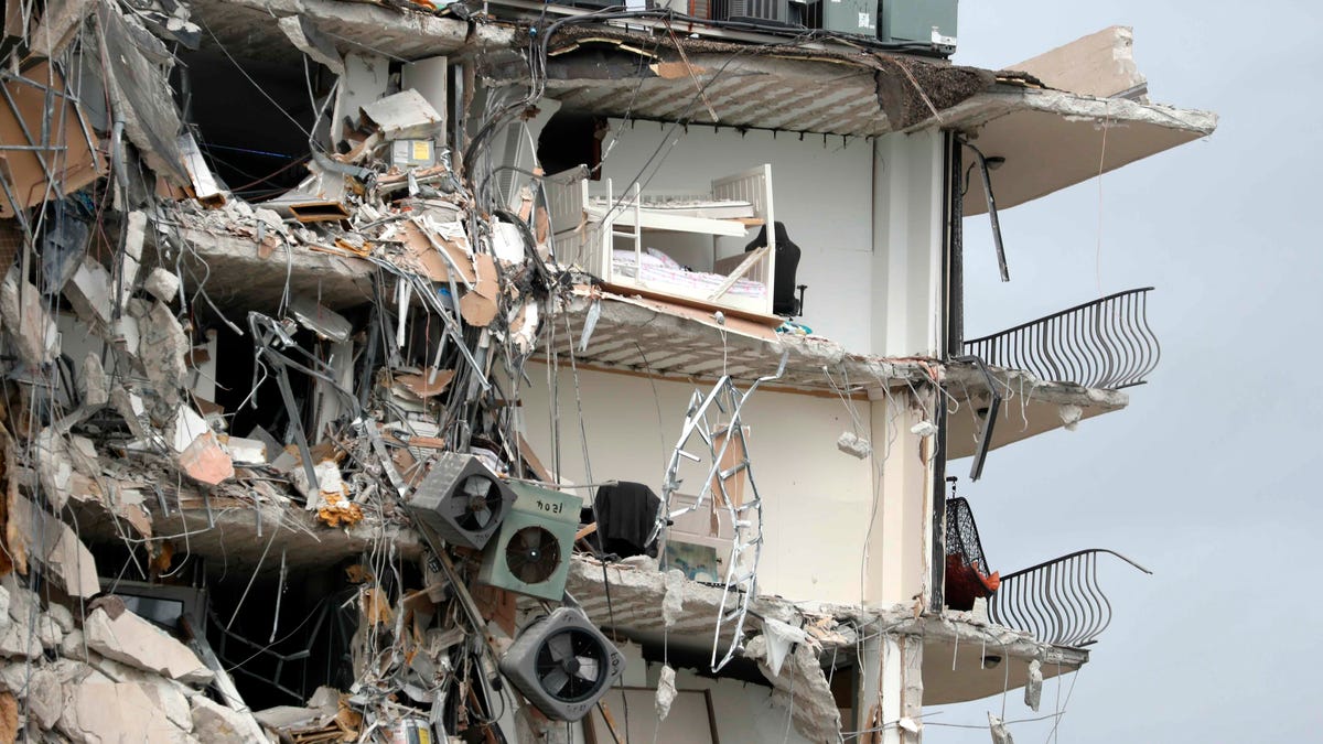 Items and debris dangle from a section of the oceanfront Champlain Towers South Condo that partially collapsed Thursday, June 24, 2021, in the Surfside area of Miami, Fla.