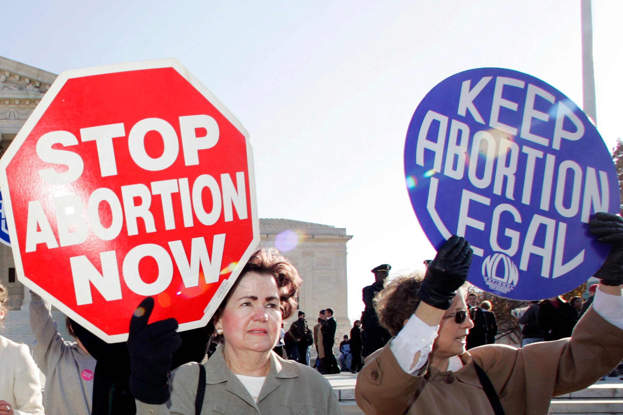 In this Nov. 30, 2005 file photo, an anti-abortion supporter stands next to a pro-choice demonstrator outside the U.S. Supreme Court in Washington.