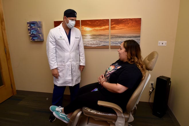 Alyssia Lopez, 28, of Oxnard, speaks with Dr. Hessam Siavash at Greater Ventura Oral & Facial Surgery in Ventura on Friday, June 25, 2021. Lopez was missing all but four of her teeth until earlier this month when she received dental implants through the surgical office's second chance program, a makeover valued at $50,000.