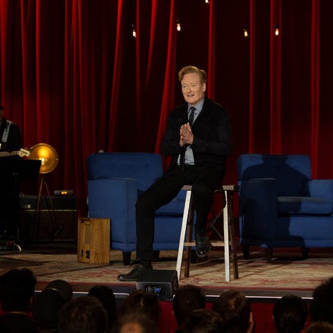 Conan O'Brien, sitting on a stool in much the same