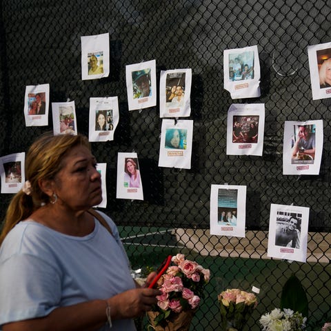 A fence with photos of unaccounted residents of th