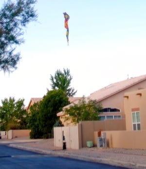 A hot-air balloon envelope falls from the sky near Unser and Central SW in Albuquerque, N.M., Saturday, June 26, 2021. Multiple people were killed in the crash.