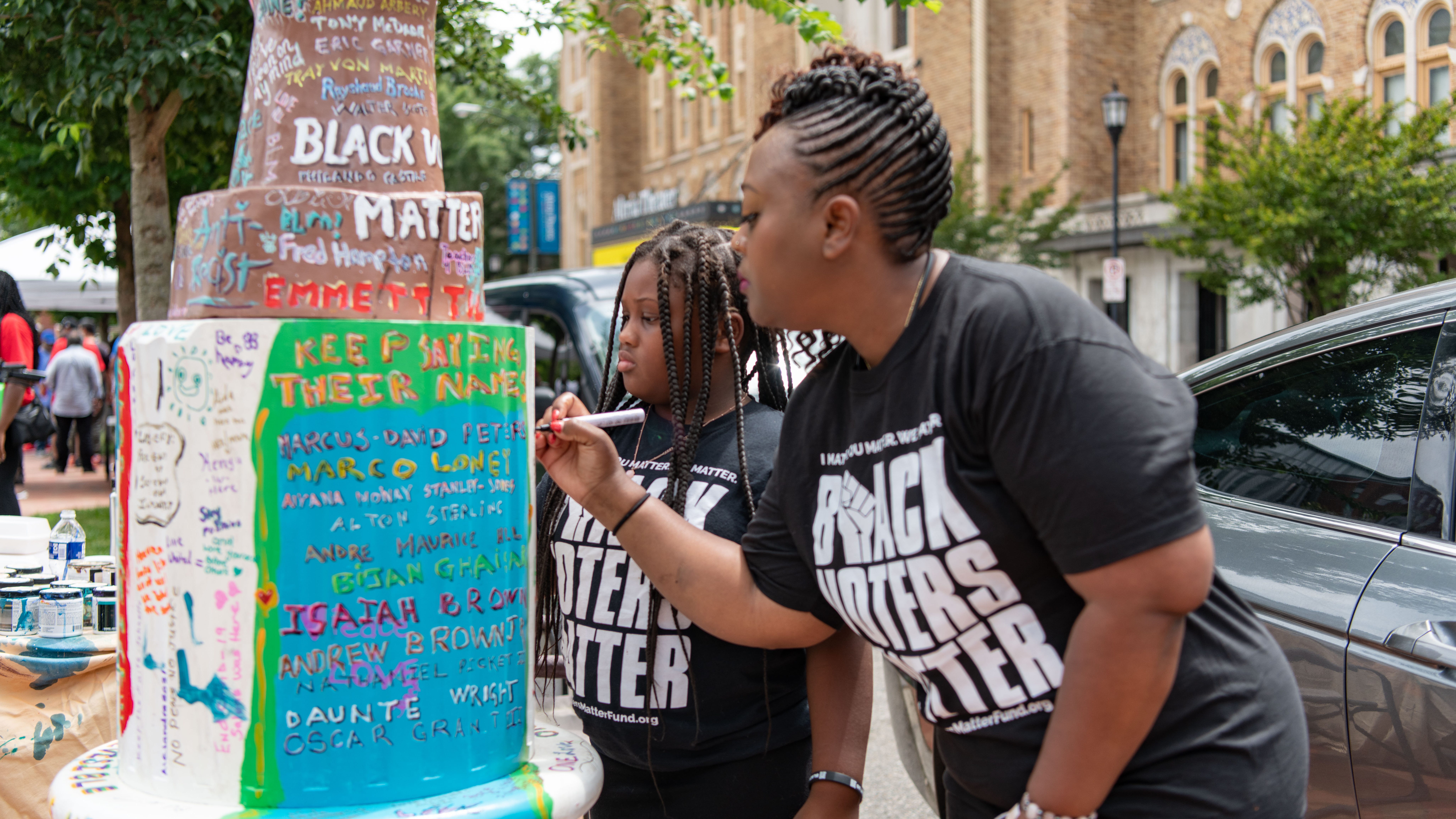 Ysrael Binns, 8, and mother Shenita of Atlanta, Georgia, add to an art installation at an event hosted by voting rights group Black Voters Matter commemorating the 60th anniversary of the Freedom Rides, and the eighth anniversary of the Shelby County v. Holder Supreme Court decision in Richmond, VA on June 25, 2021.